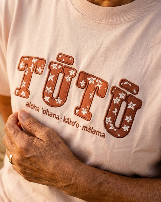 Hawaiian woman grandma wearing a light pink tutu shirt. Hawaiian affirmation apparel.