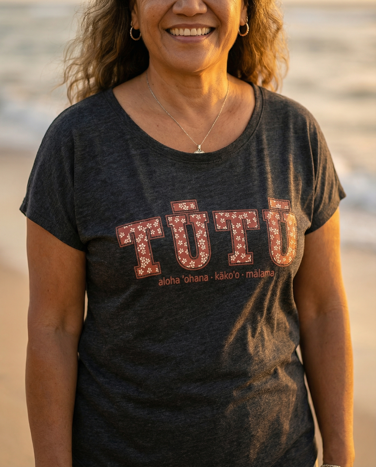Pua Kukui Tūtū womanʻs dolman shirt in vintage black.