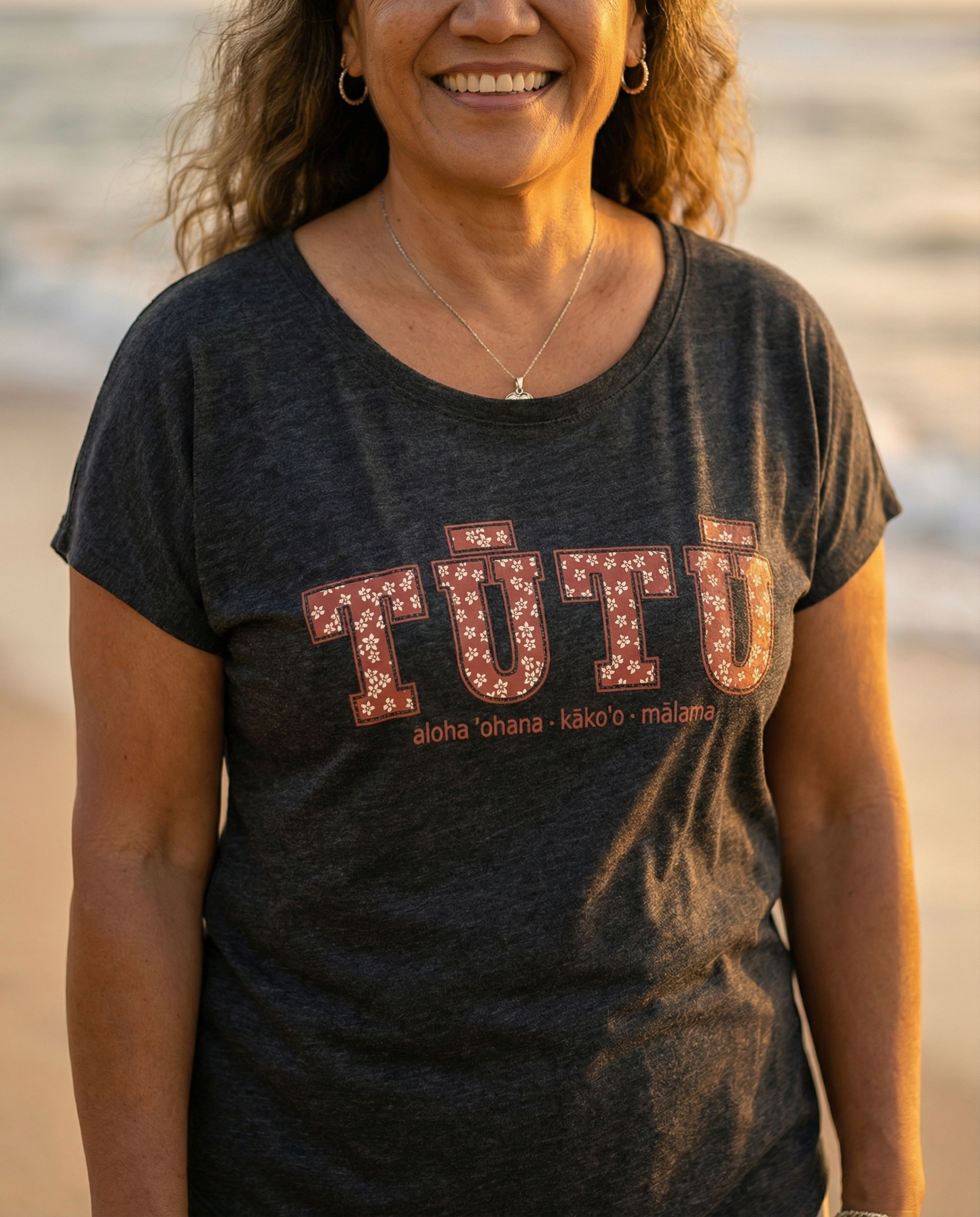 Pua Kukui Tūtū womanʻs dolman shirt in vintage black.